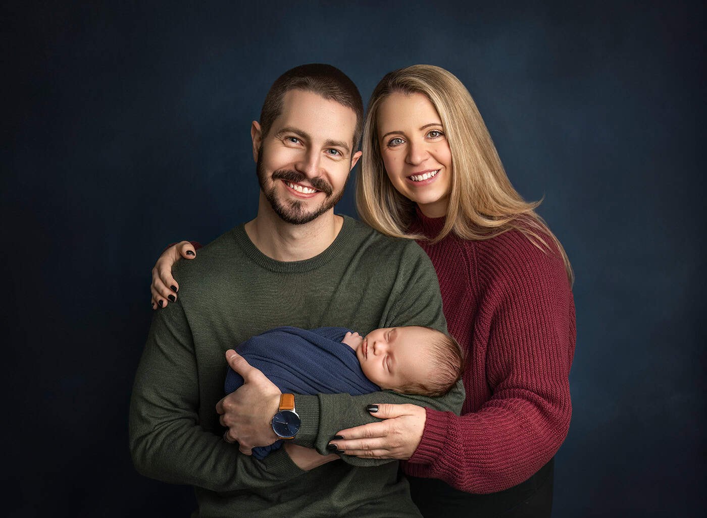 newborn boy photos parents holding their newborn son looking at the camera