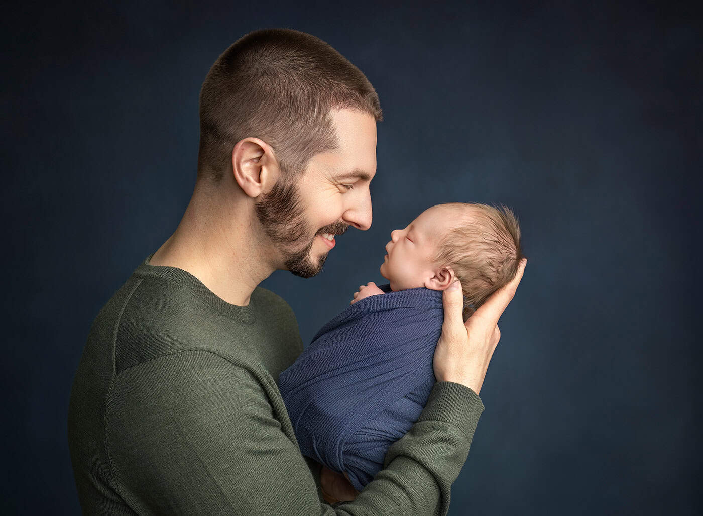 newborn boy photos Dad holding his newborn son nose to nose in profile