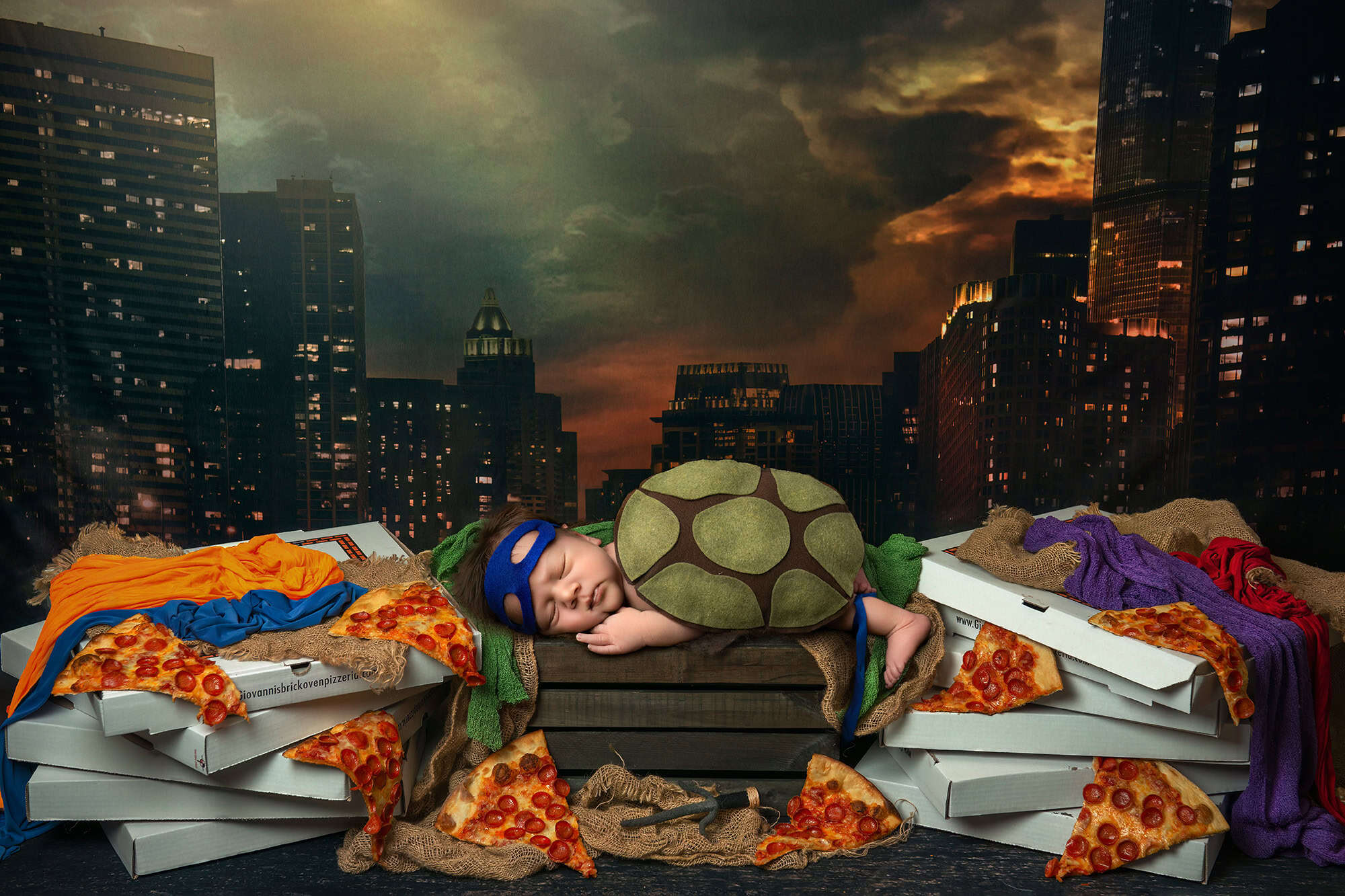 Ninja Turtles inspired city scene with newborn in turtle shell and pizza boxes.