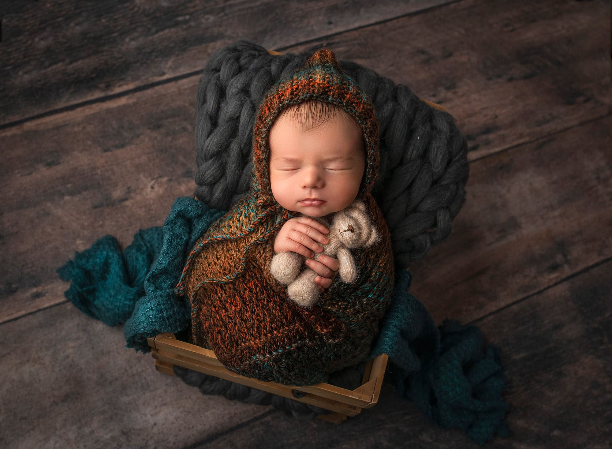how to prepare for newborn photoshoot Glastonbury CT newborn baby boy sleeping in a crate holding a teddy bear