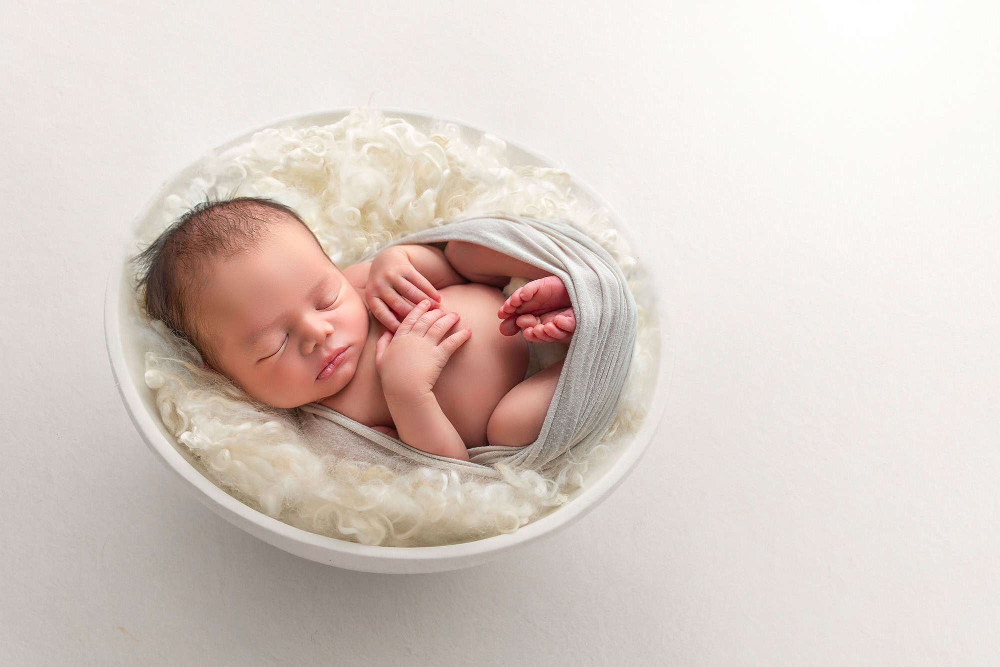best newborn photographer best time to take newborn photos baby sleeping in a bowl