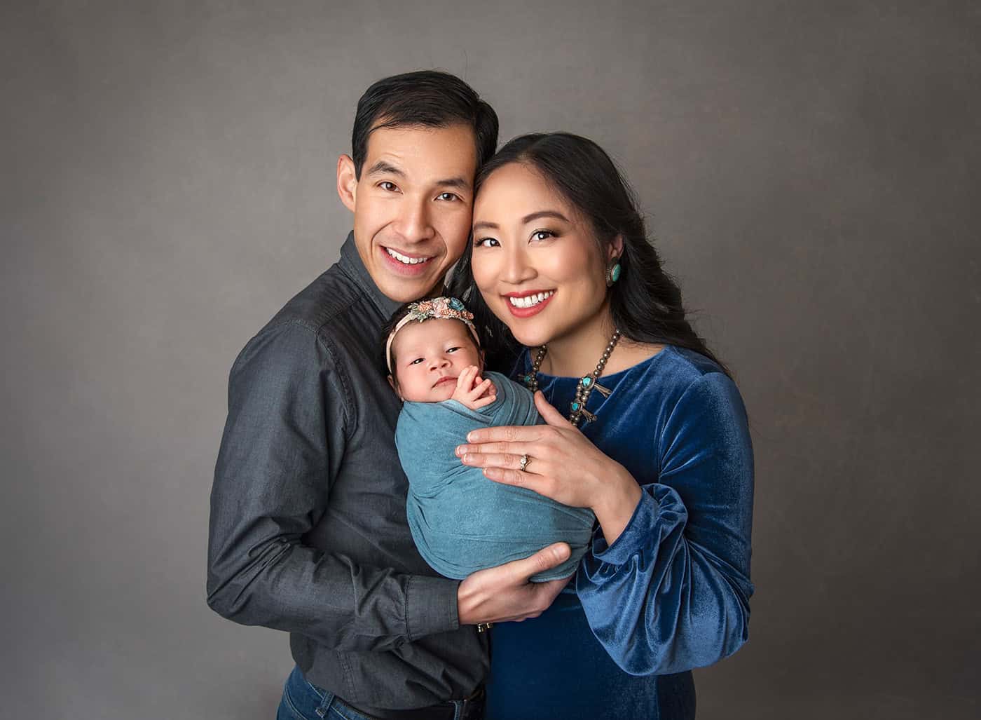 best newborn photographer Luxury Newborn Photography parents holding their new baby girl and smiling