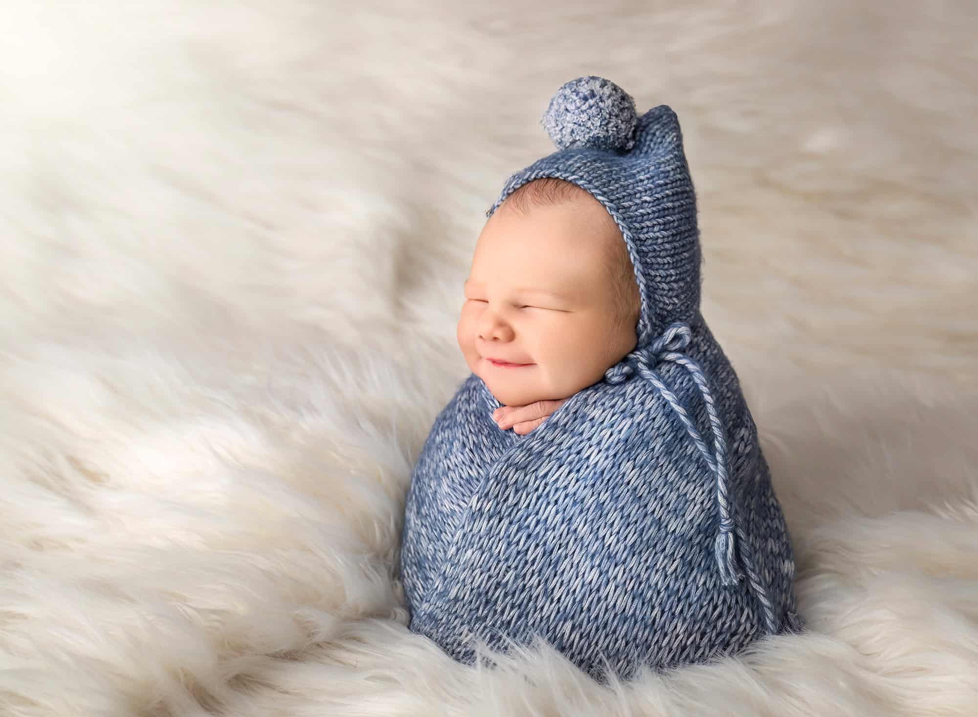 Newborn in potato pose wrapped in knit swaddle during professional Glastonbury CT session.