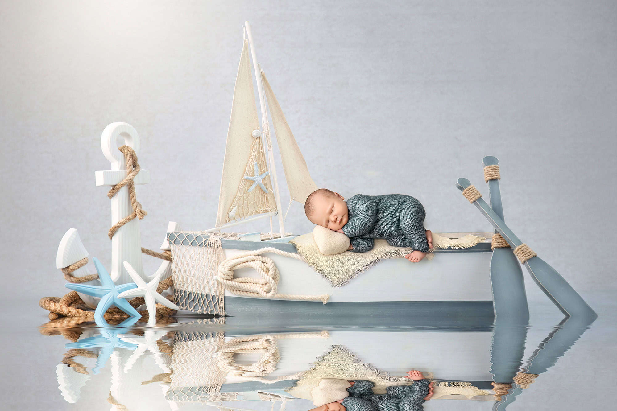 Nautical newborn portrait with rowboat, anchor, and starfish created in Glastonbury CT studio.