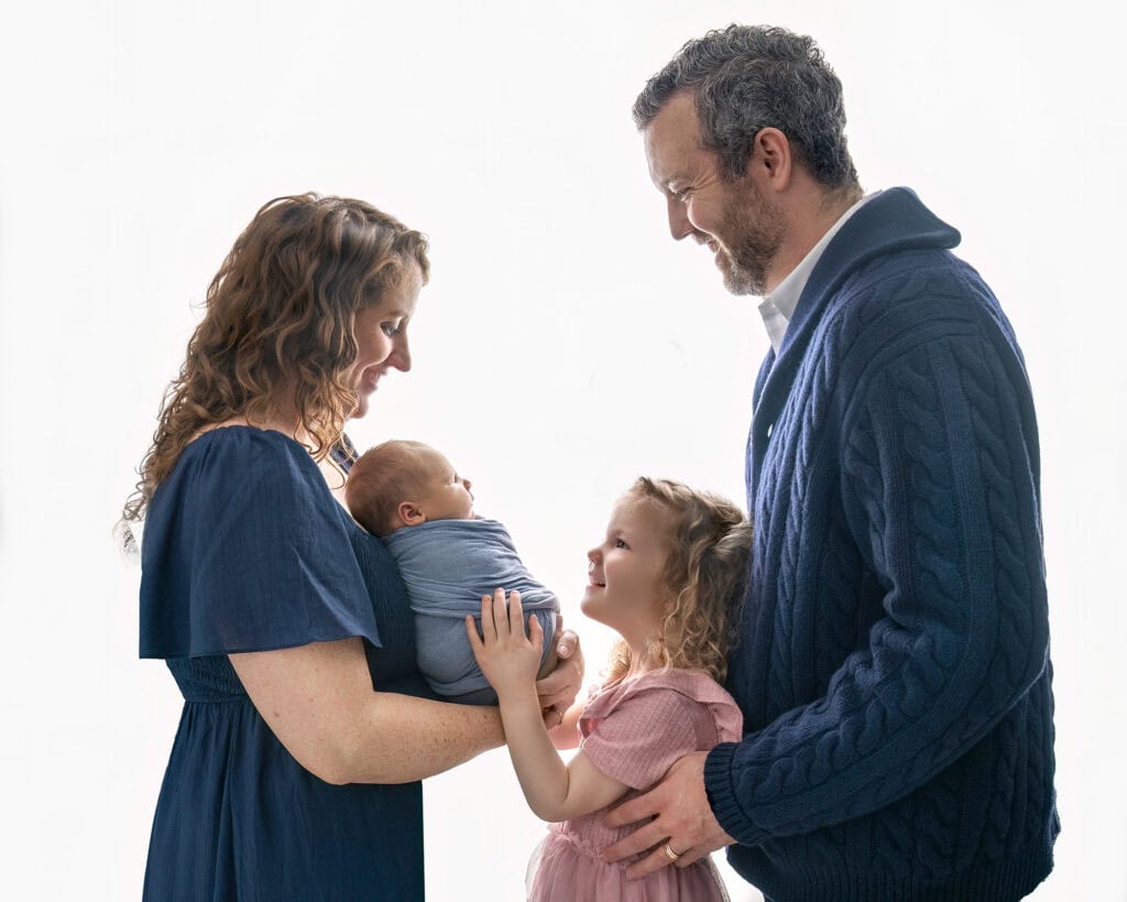 Family gazing lovingly at baby Tommy