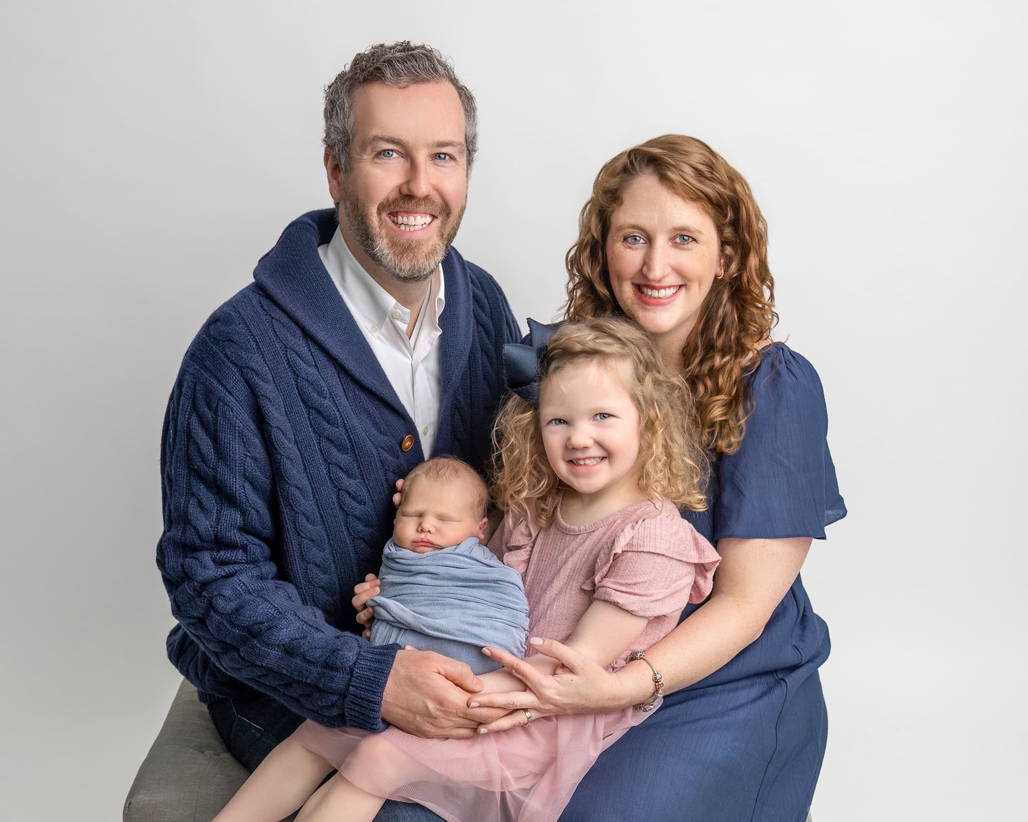 Family portrait in Glastonbury CT newborn photography studio with parents holding their baby.