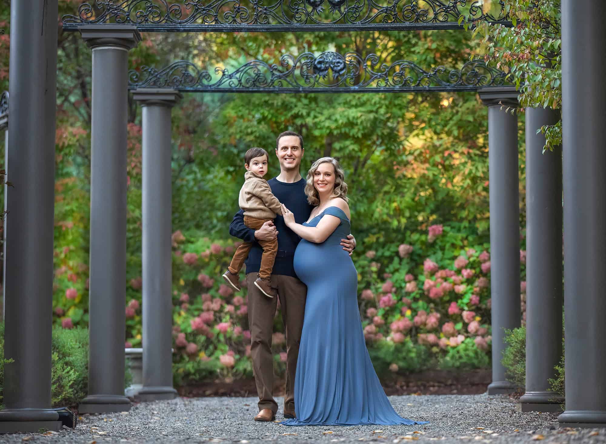 maternity and newborn photography pregnant mom and her husband and toddler son in beautiful park with columns