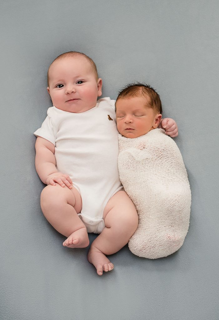 3 month old baby boy snuggles newborn baby brother