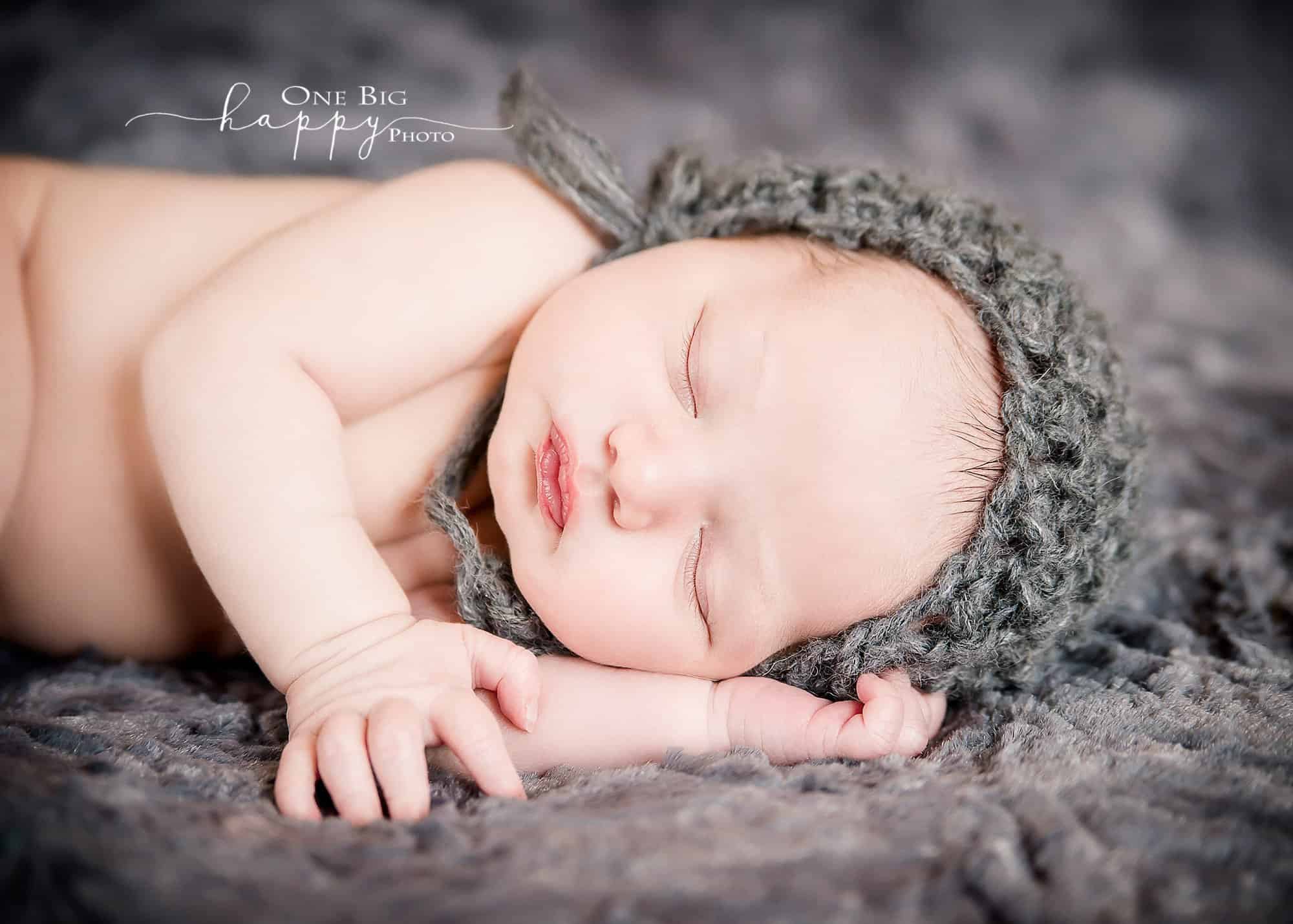 Newborn baby boy sleeping in grey knit cap on grey blanket Glastonbury CT Newborn Photographer One Big Happy Photo www.onebighappyphoto.com/newborns