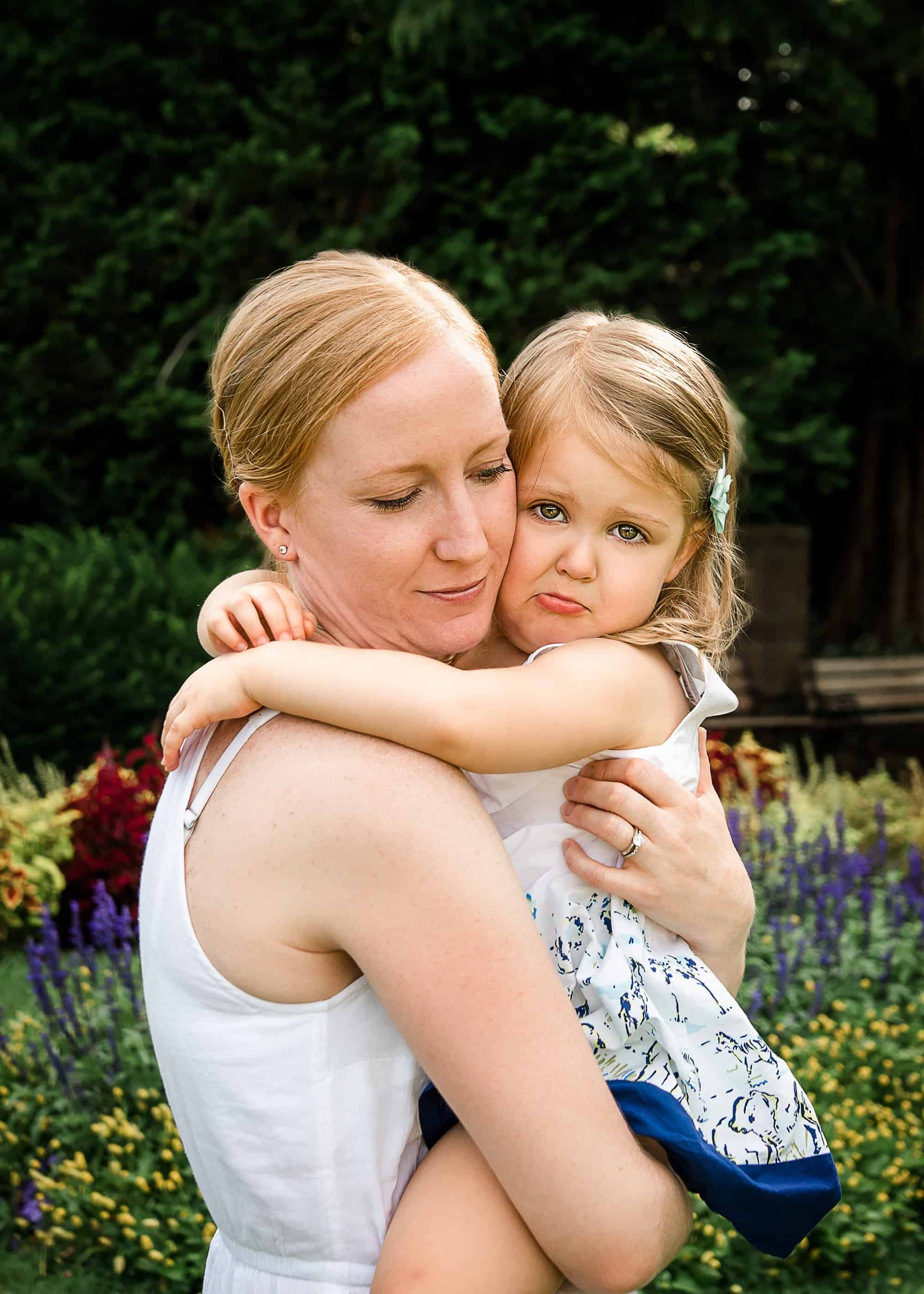 Momma comforting her crying 3 year old girl with a hug