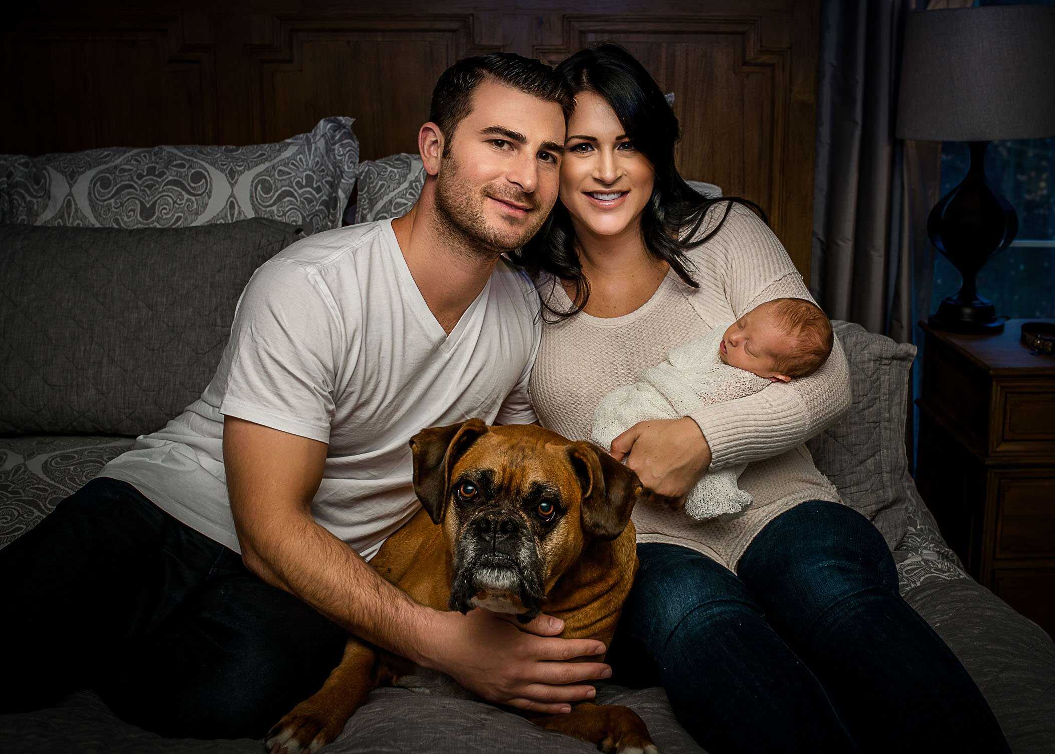 New mom and dad with their dog and newborn baby girl