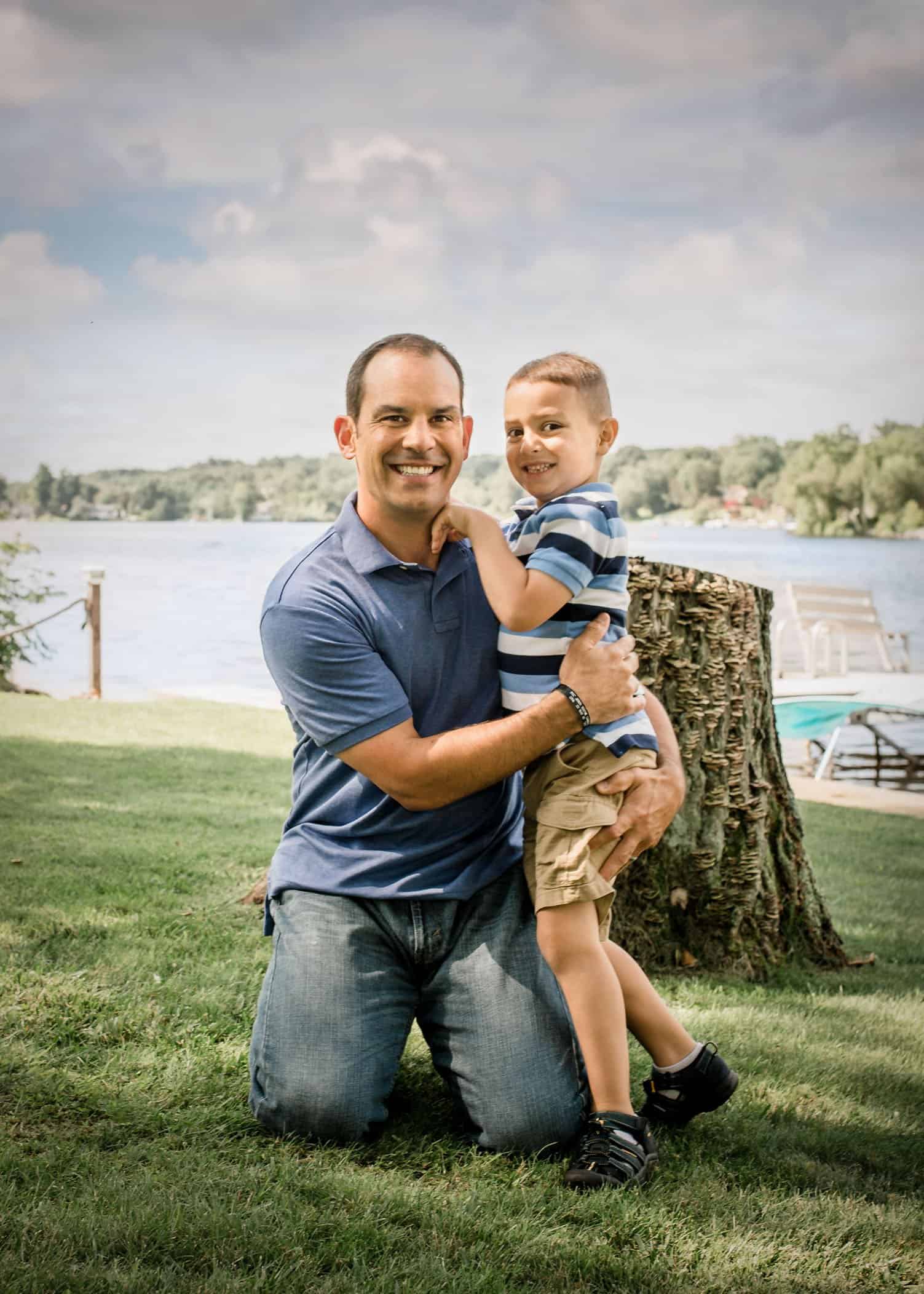 Dad catching a quick hug from his excited 5 year old son down by the lake