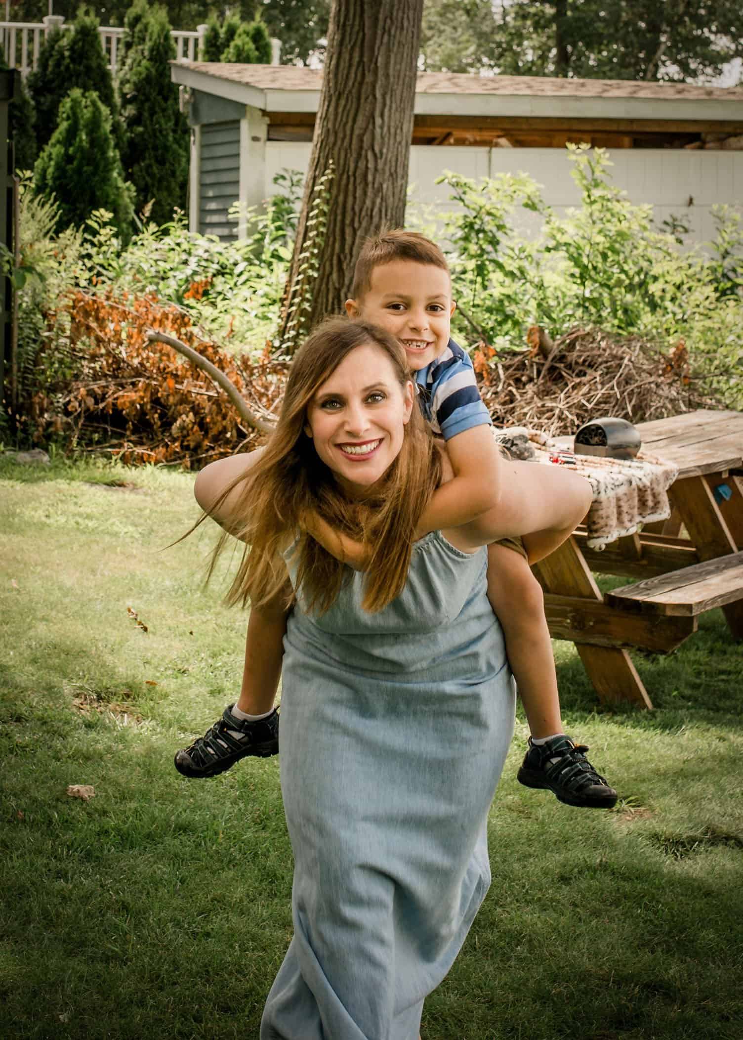 Mom giving a piggy back ride to her 5 year old son