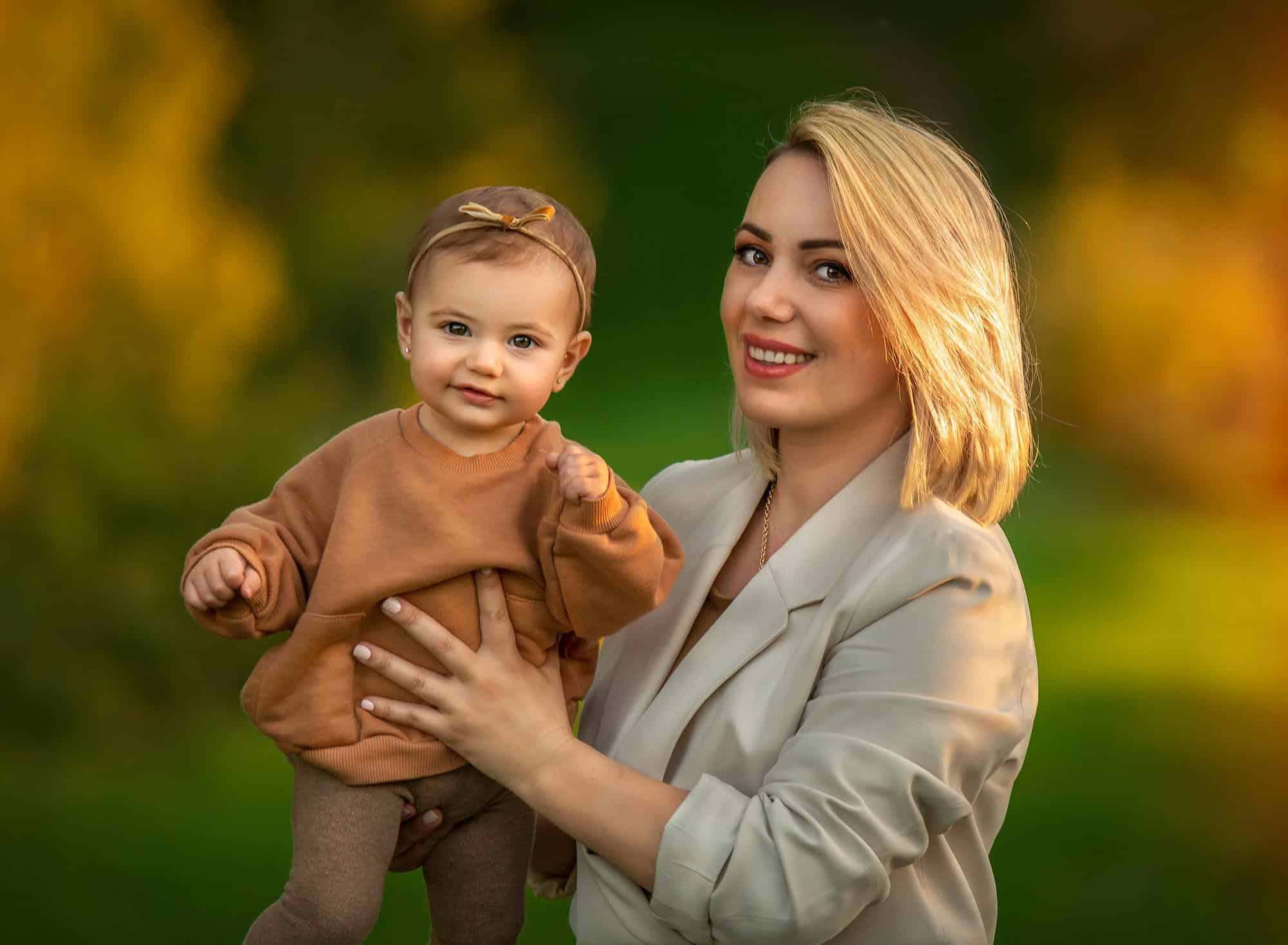 mother holding up daughter wearing amber sweatshirt