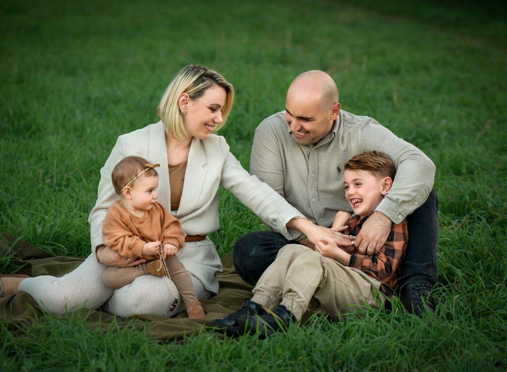 How to prepare for a family photoshoot Outdoor family photoshoot in Glastonbury CT husband and wife giggling while looking at their son and daughter