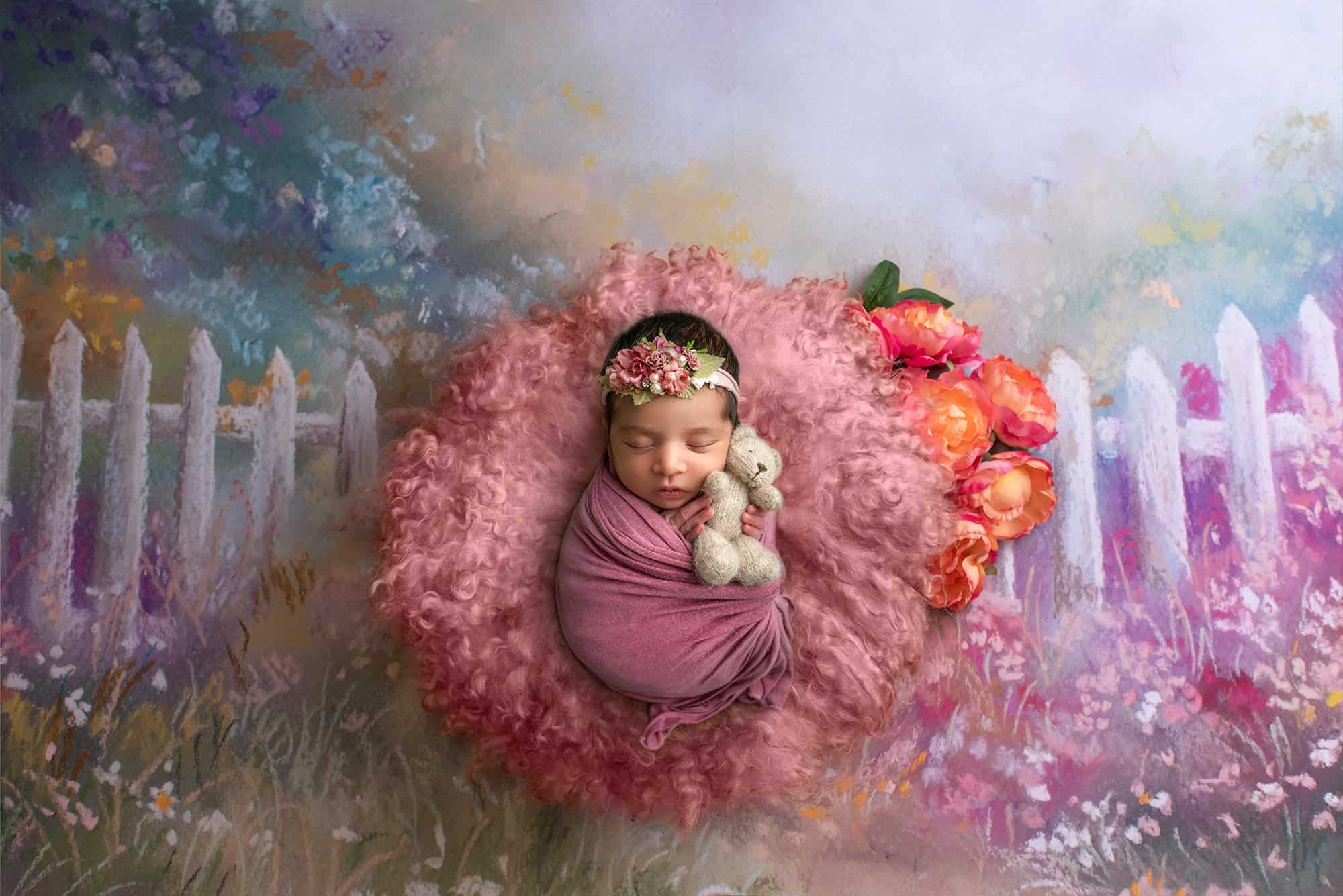newborn baby girl asleep in a floral pasture