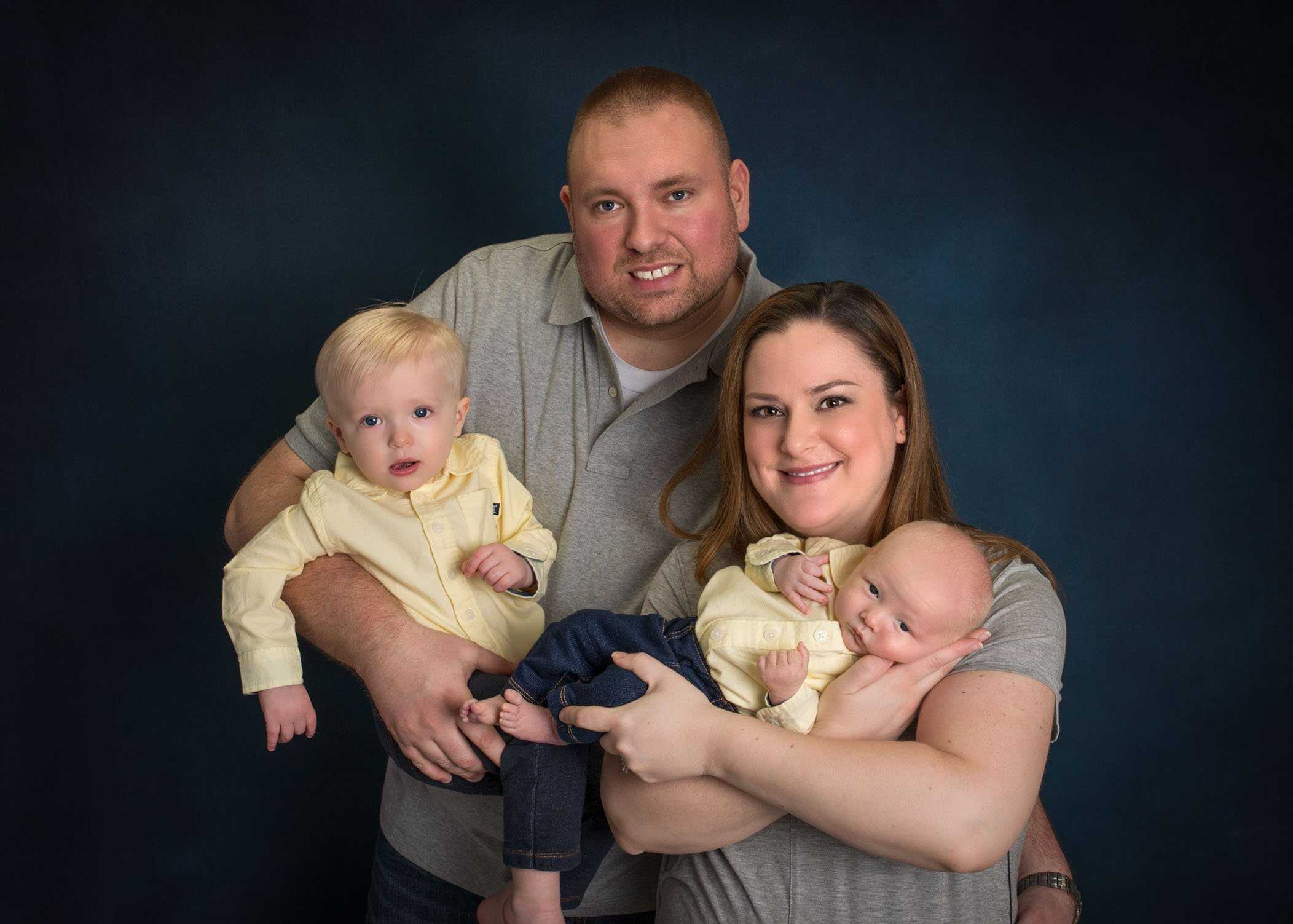 family of 4 with newborn in mom's arms