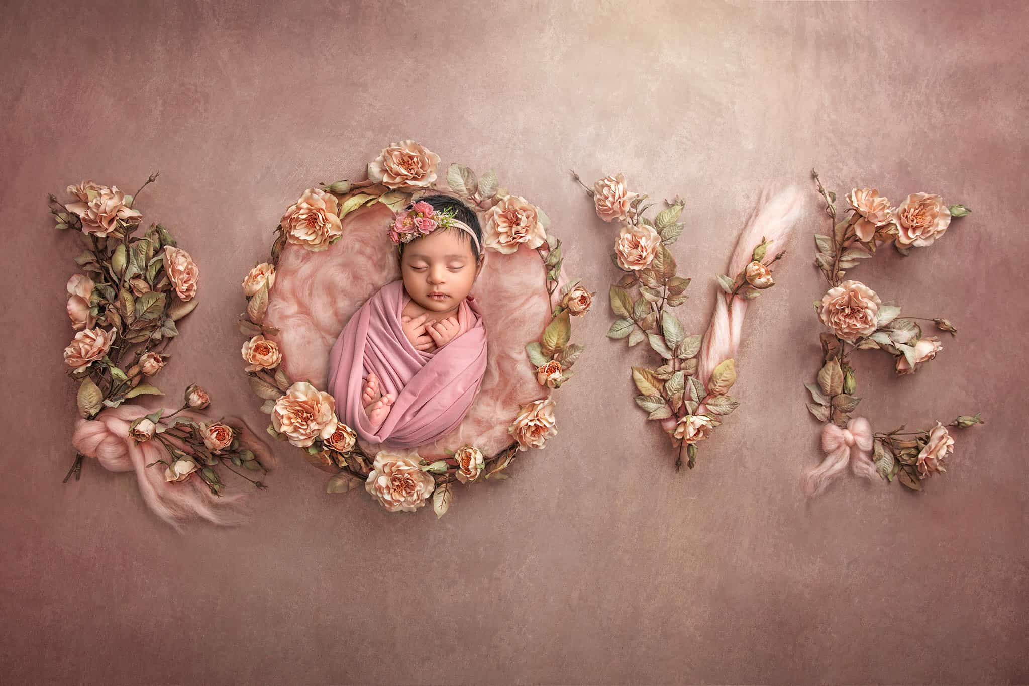 Word “LOVE” spelled in roses with baby Dhanya sleeping in the letter “O"