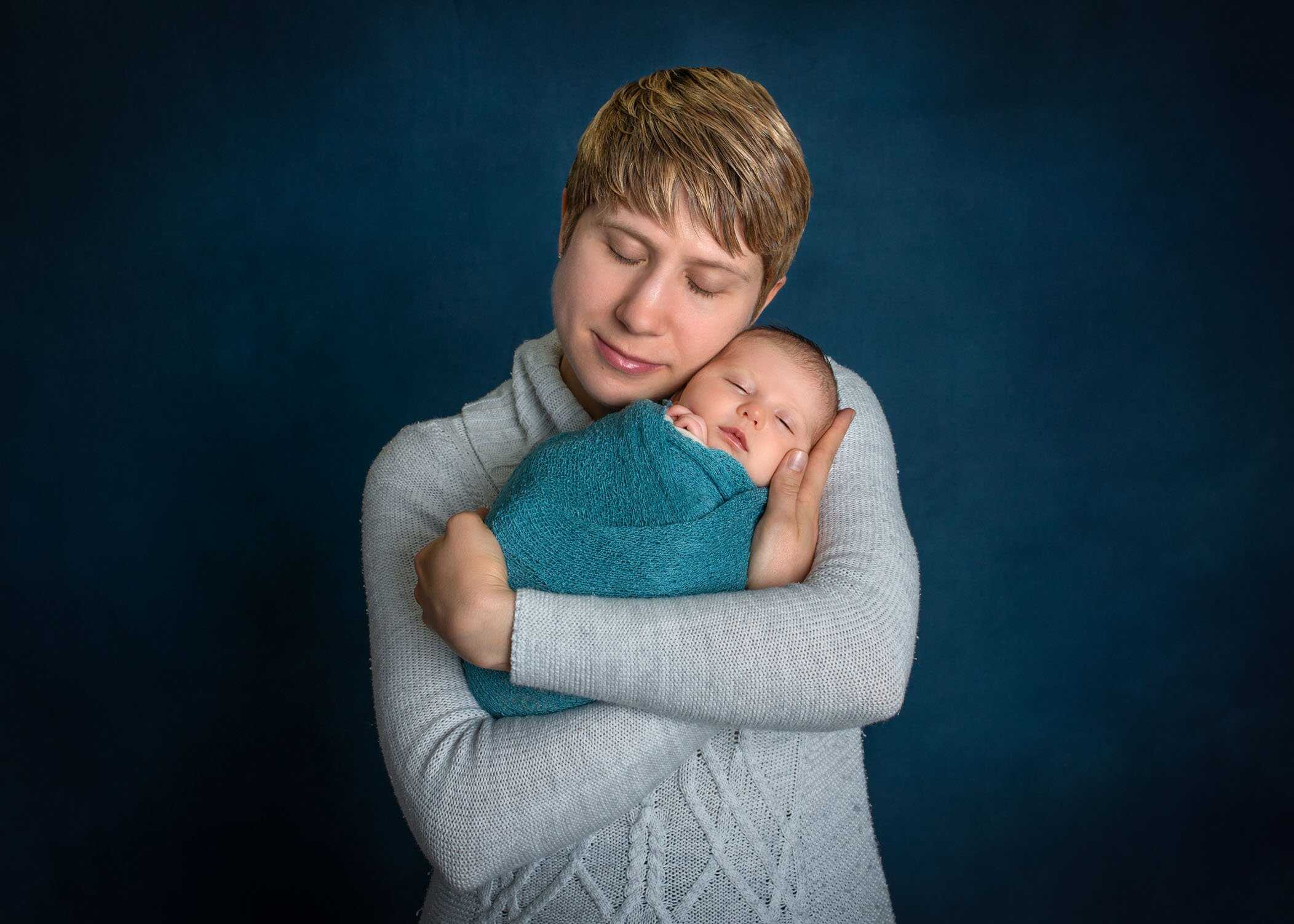 mom hugging newborn in her arms