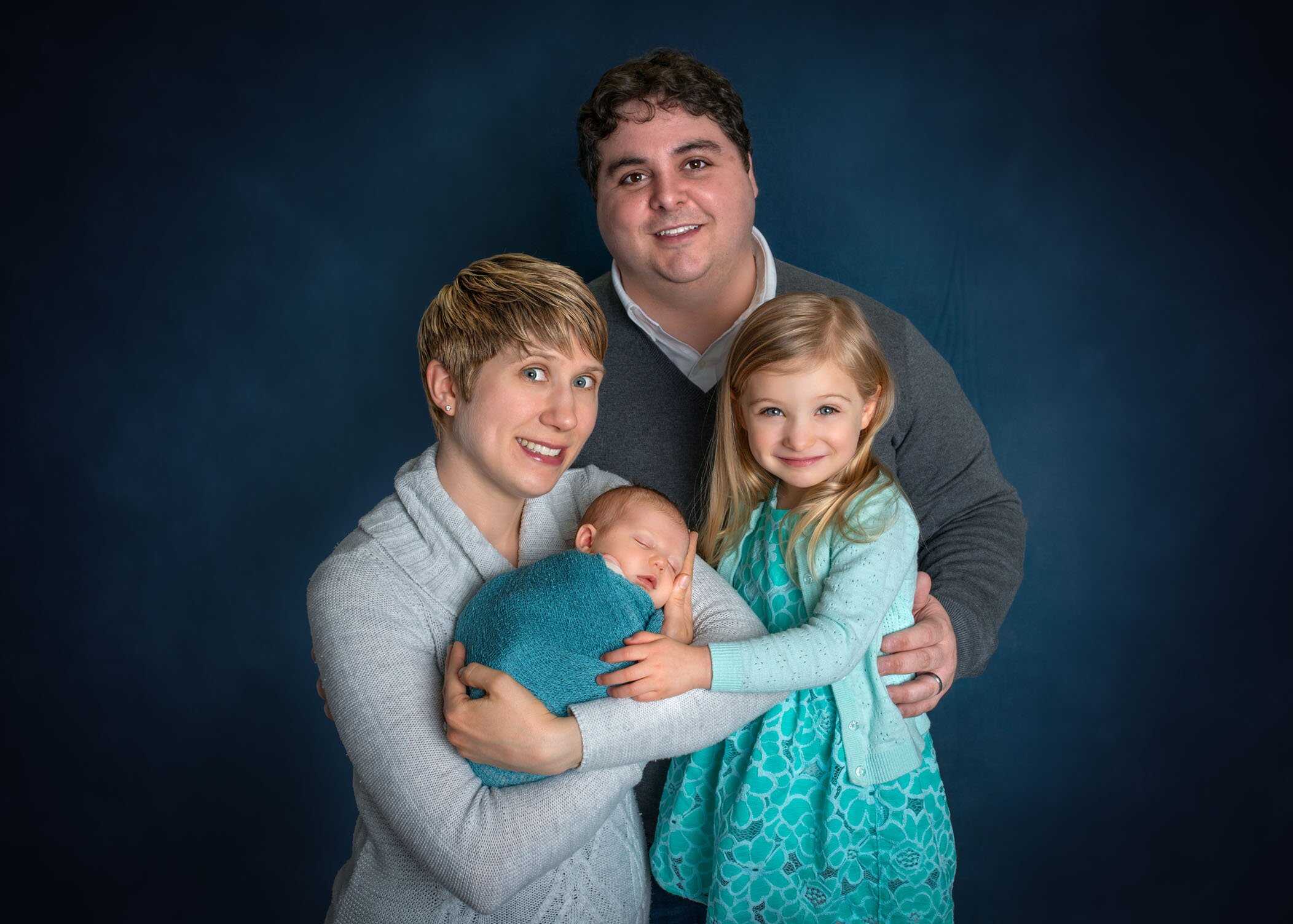 family of 4 with newborn in mom's arms