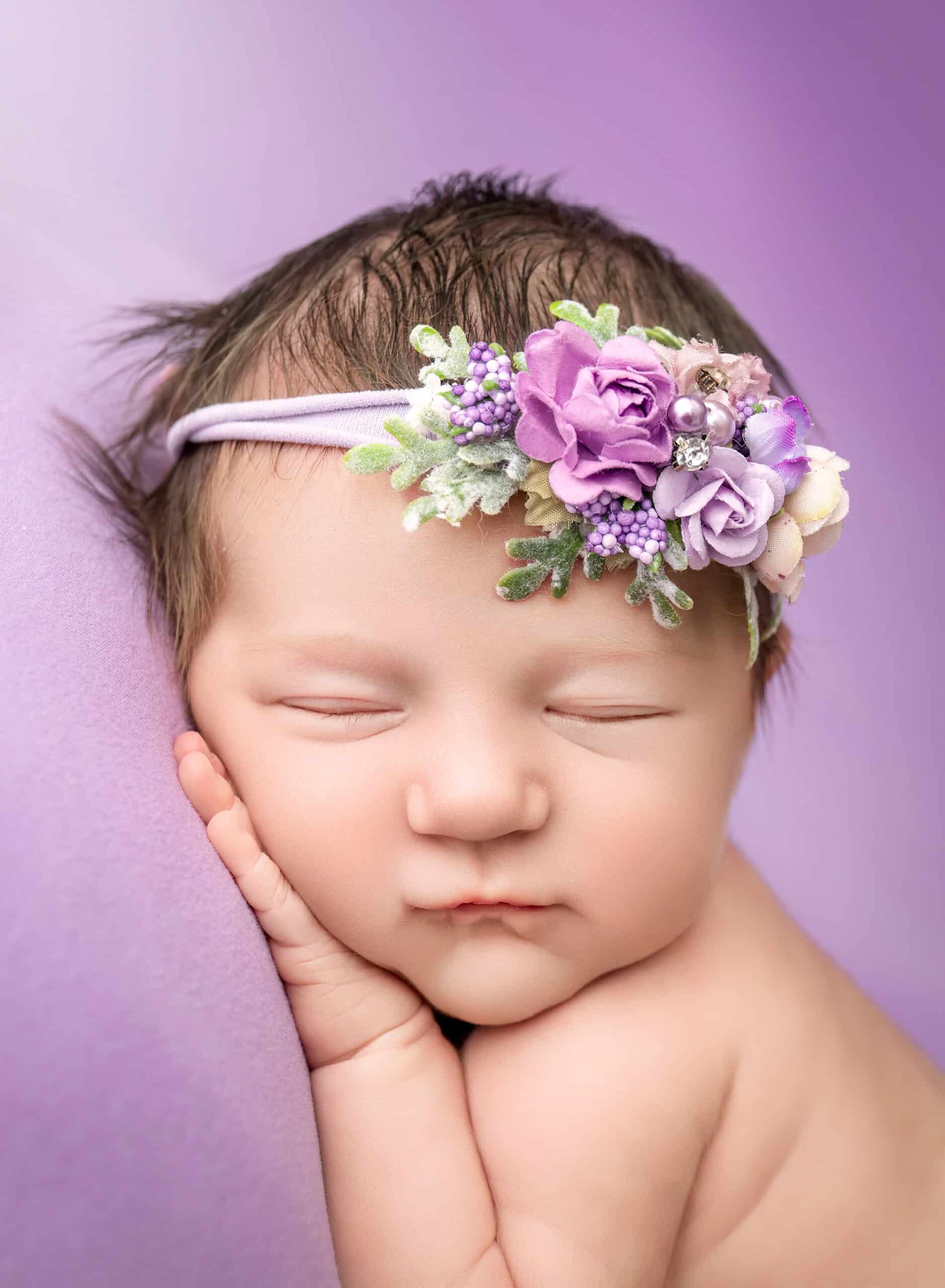 newborn photos with siblings — close-up floral headband on sleeping baby