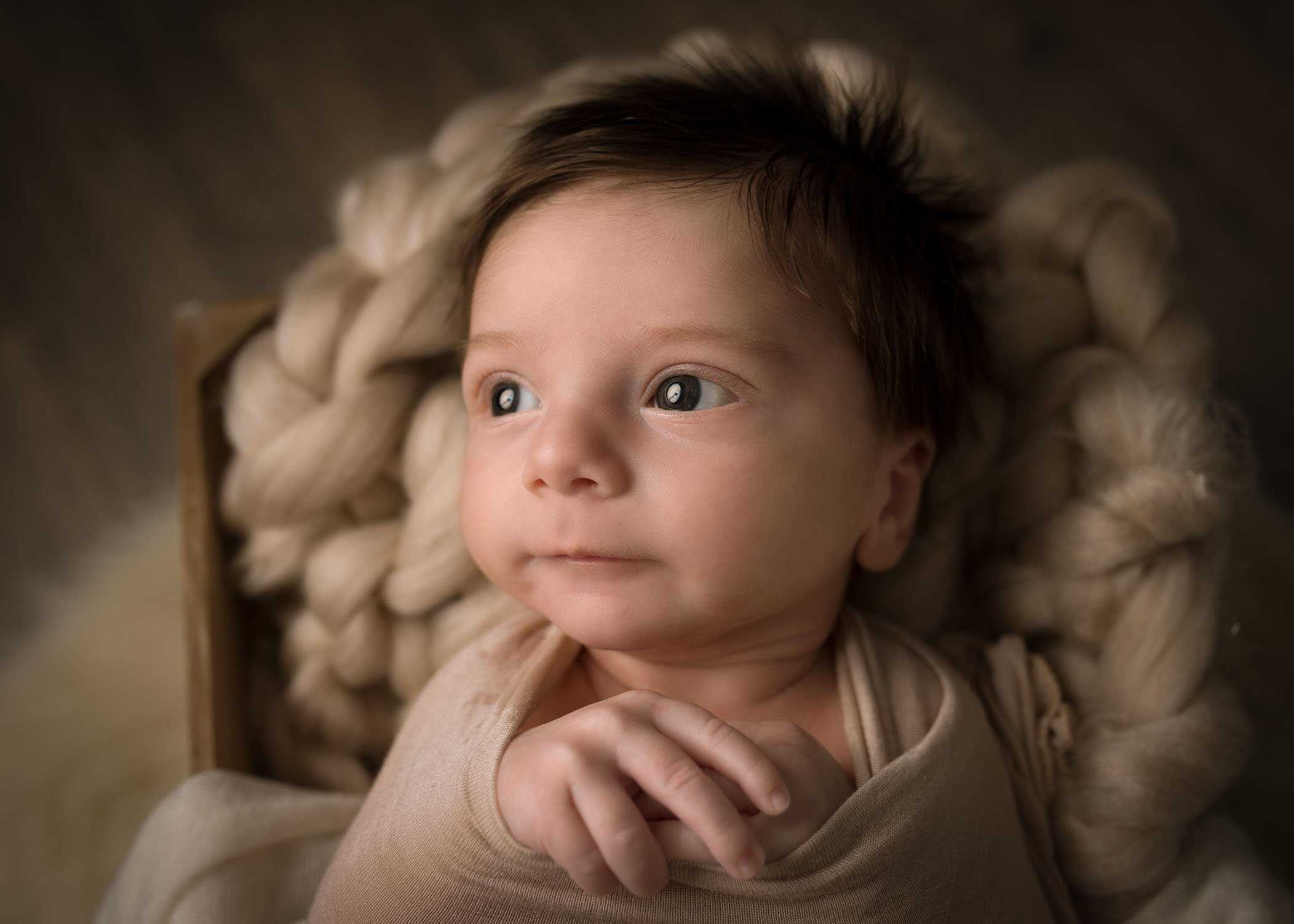 newborn baby boy awake looking to left calmly
