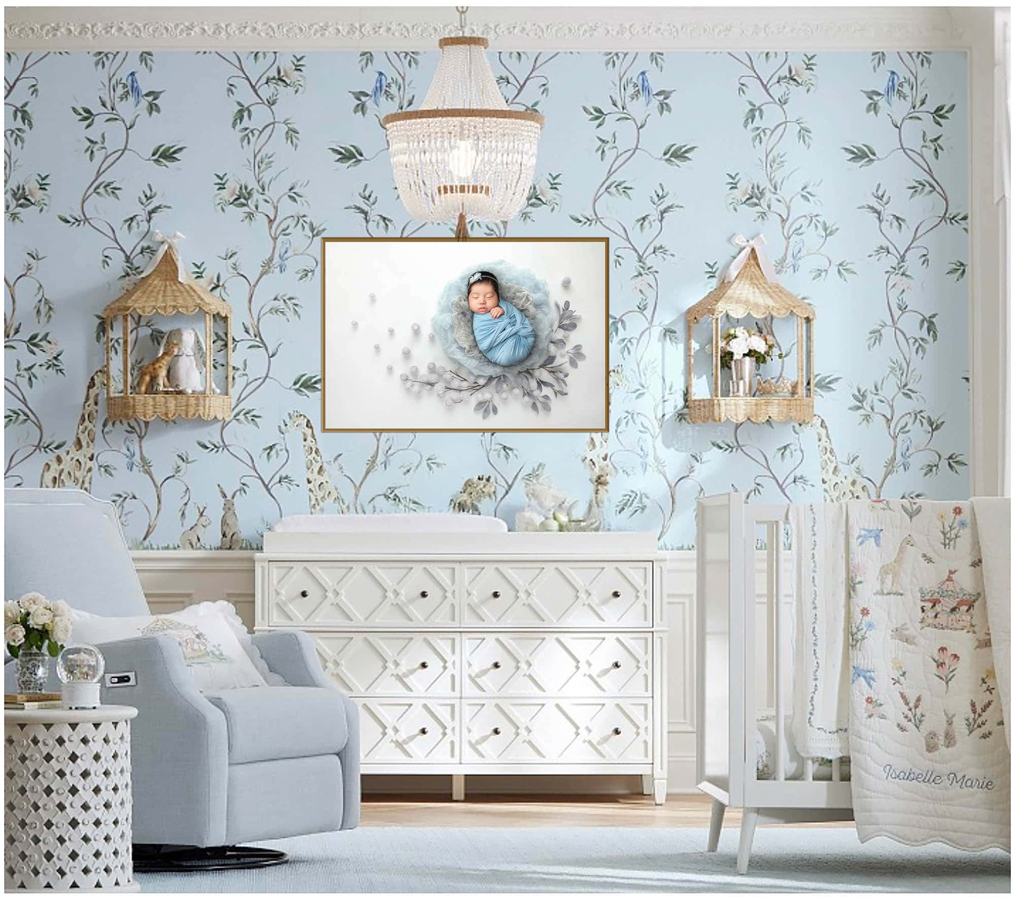 Newborn swaddled in pale blue within soft grey-blue nest and airy botanicals in a nursery.