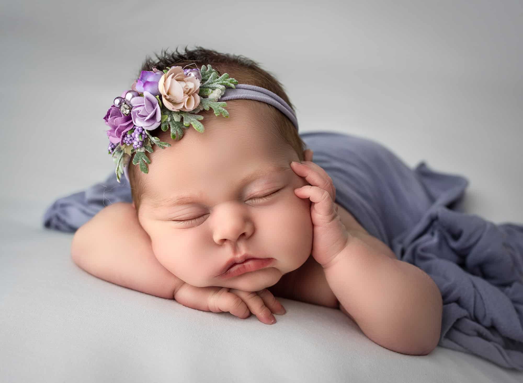 best newborn photography newborn baby sleeping with her head on her hands with one hand resting on her cheek