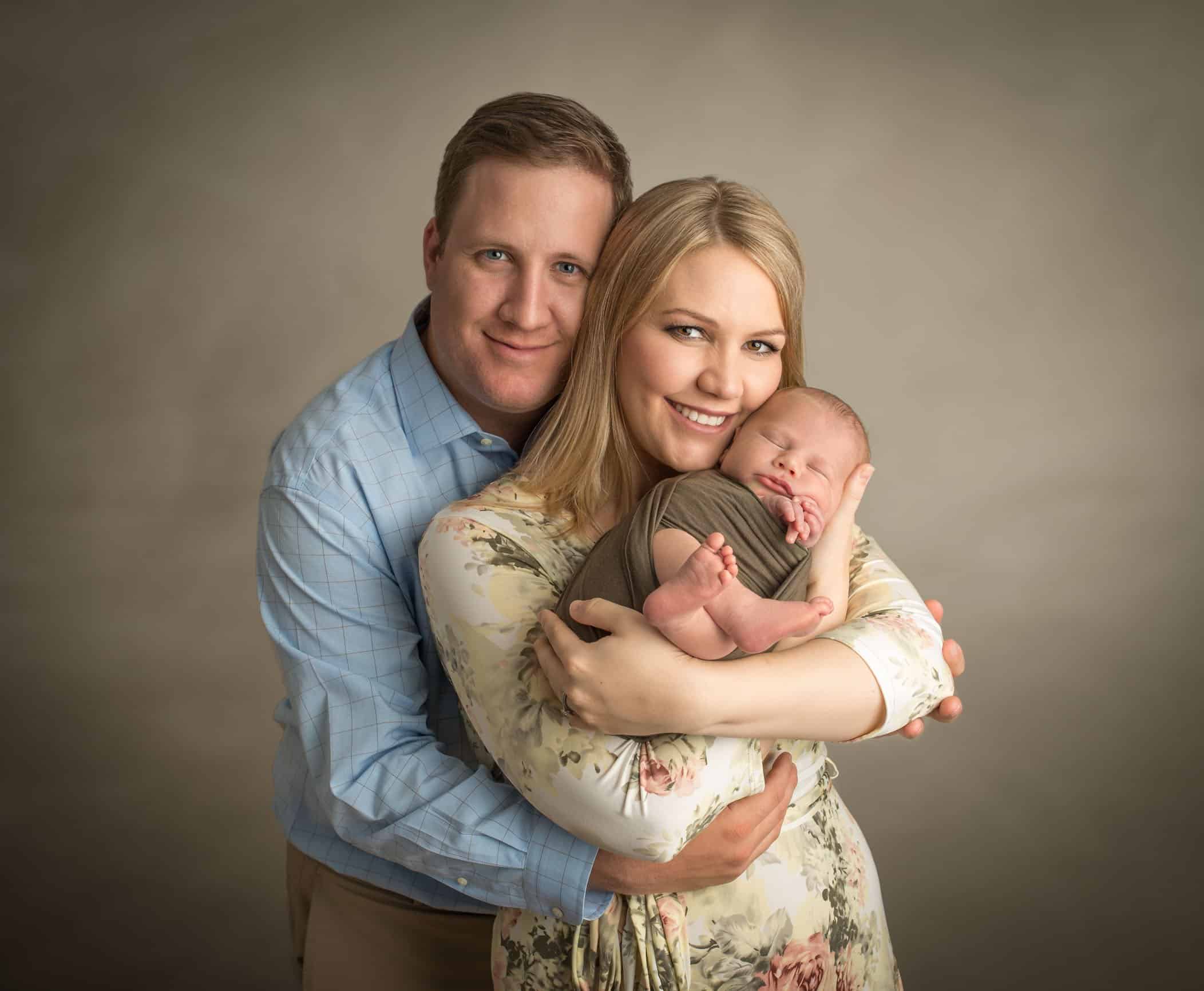 mom and dad holding rainbow baby boy