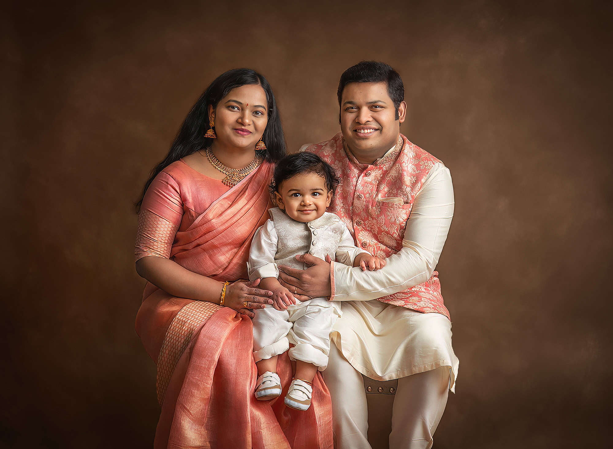 family professional pictures mom dad and 1 year old boy dressed in traditional indian attire for a formal family portrait