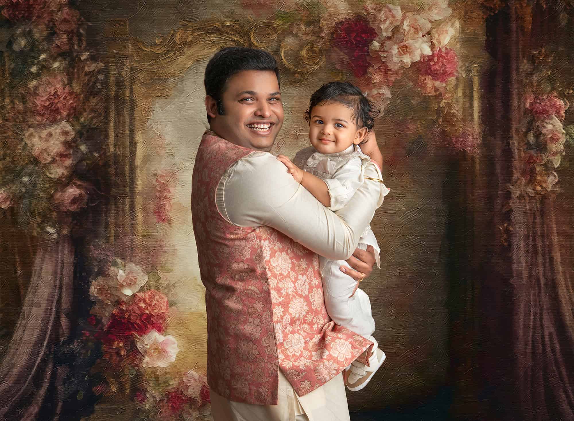 in studio family photos indian dad dressed in traditional indian attire holding his 1 year old son in a formal portrait