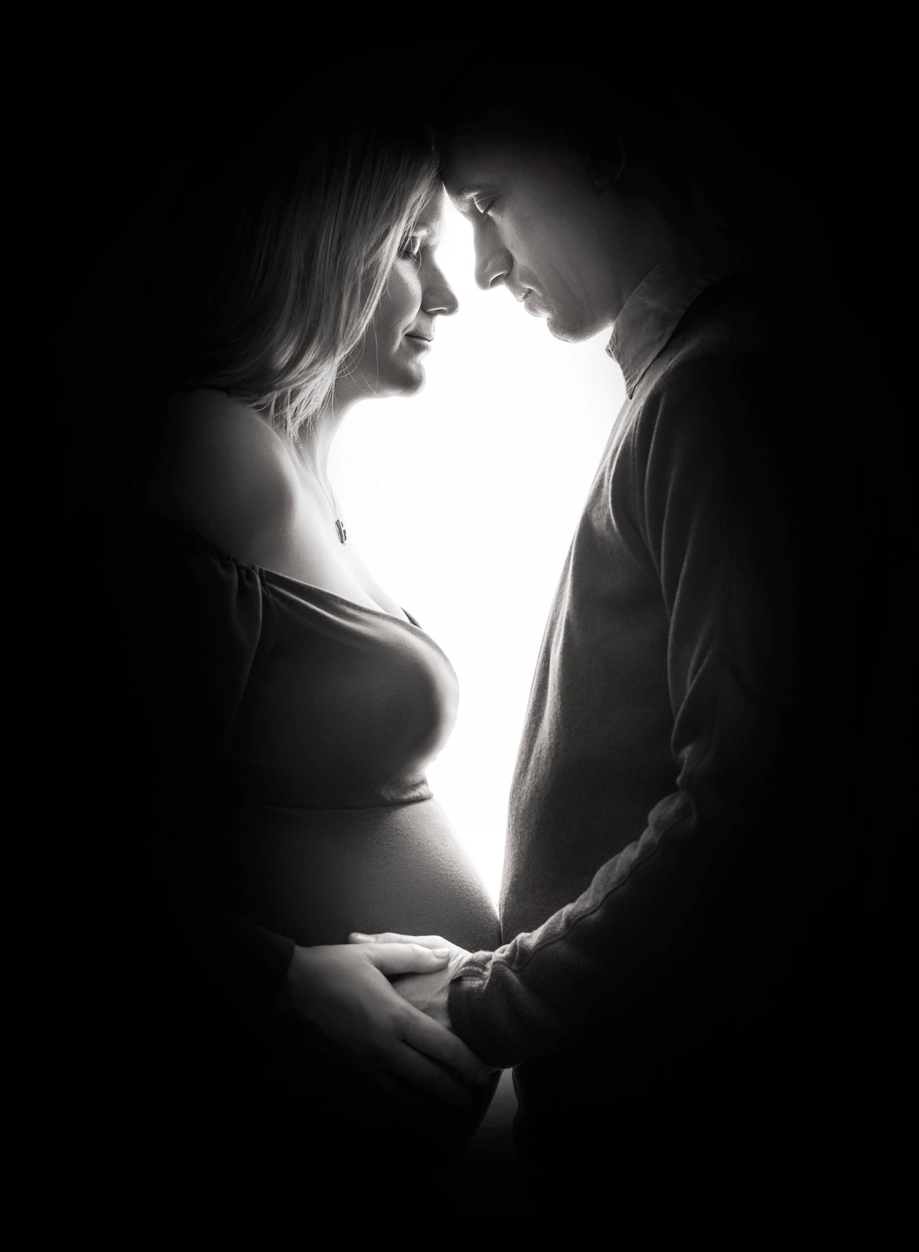 maternity and newborn photoshoot Dad joined in for a timeless black and white maternity portrait, their connection apparent as they lovingly cradled Mom’s growing bump.