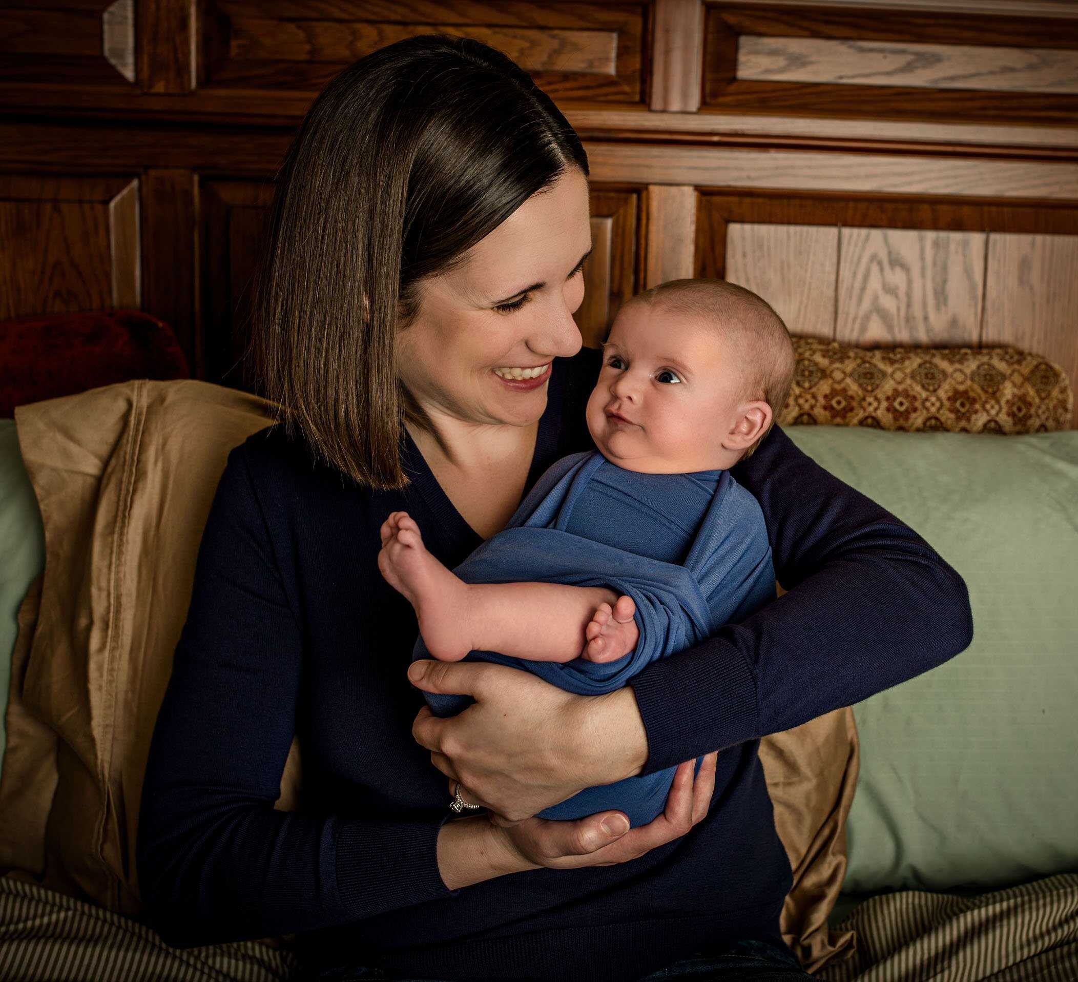 Mom holding baby son funny face