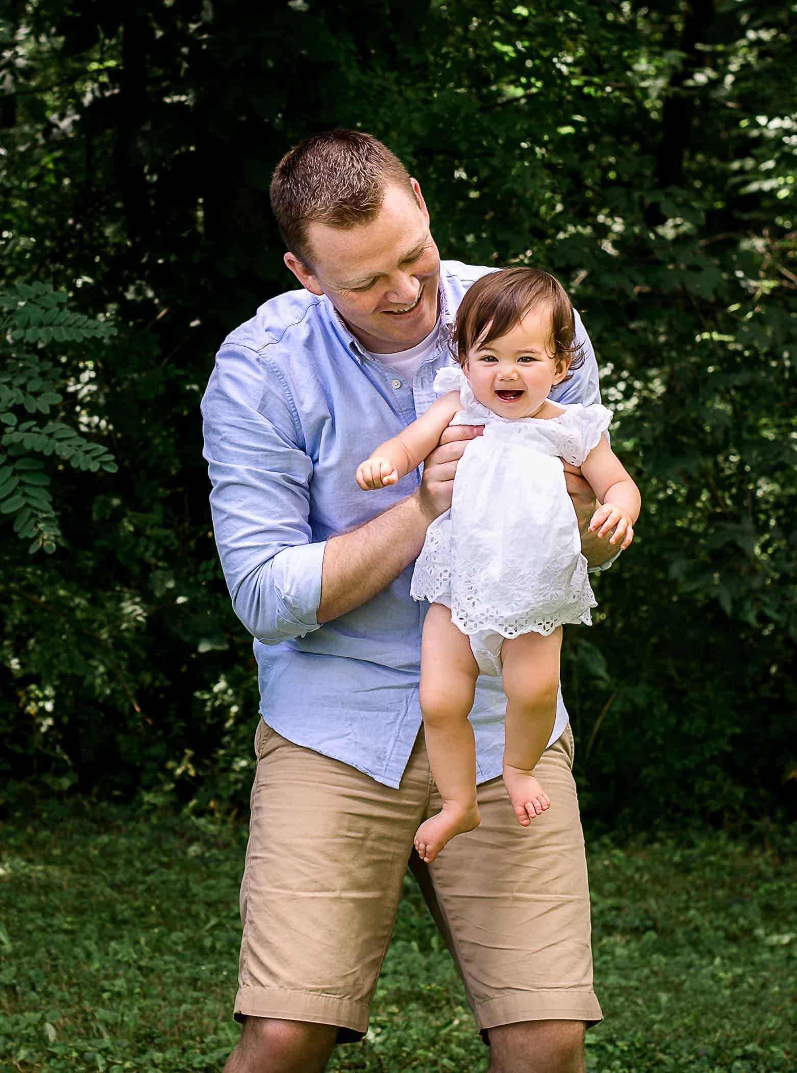 one year old baby girl being caught in air by Daddy One Big Happy Photo