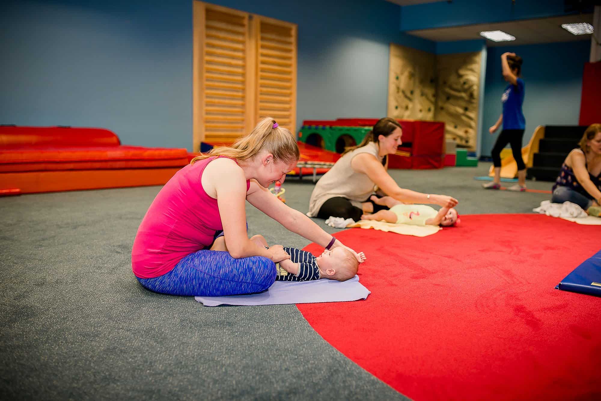 Mom playing a "move your arms up and down" game with her 6 month old son